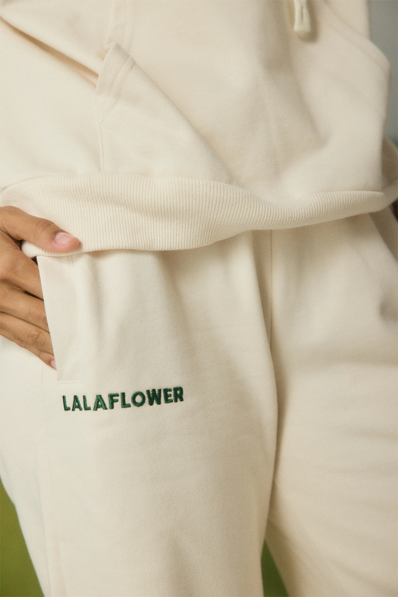 OFF-WHITE SWEATPANTS WITH GREEN EMBROIDERY